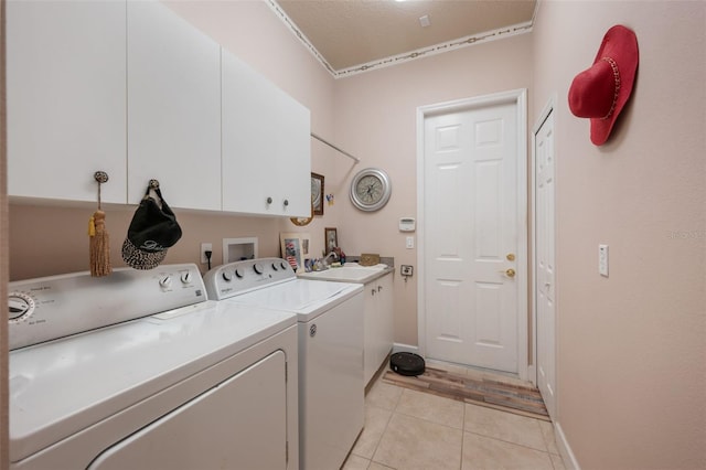 laundry area with cabinets, a textured ceiling, sink, independent washer and dryer, and light tile patterned flooring