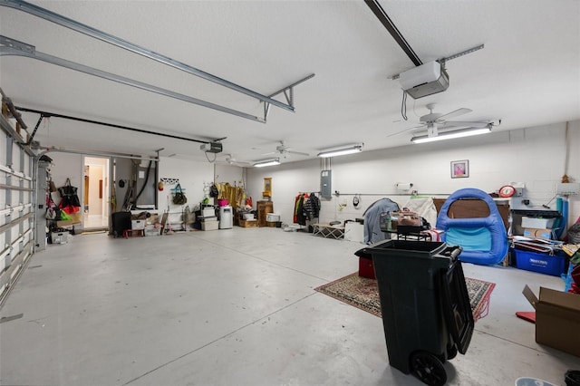 garage with electric panel, ceiling fan, and a garage door opener