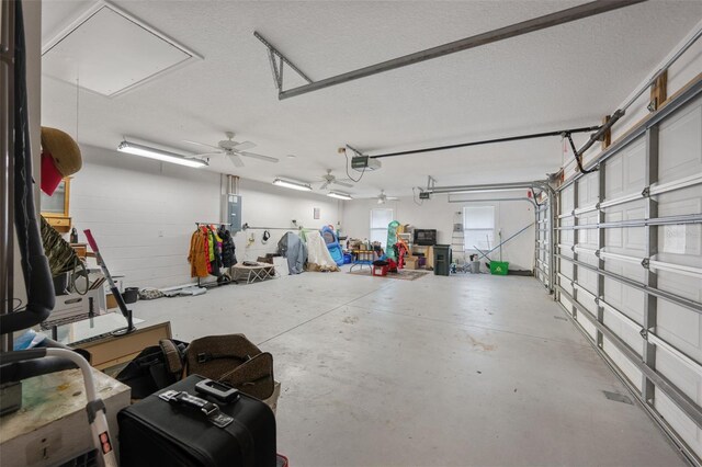 garage with ceiling fan, electric panel, and a garage door opener