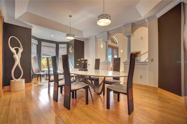 dining room with light hardwood / wood-style floors, ornamental molding, french doors, and decorative columns