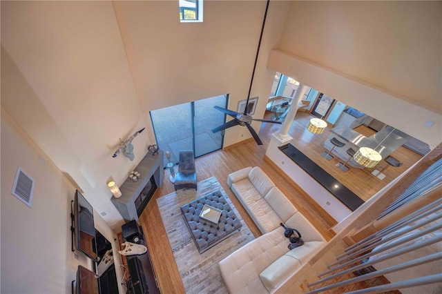 living room featuring a high ceiling, light hardwood / wood-style floors, and a wealth of natural light