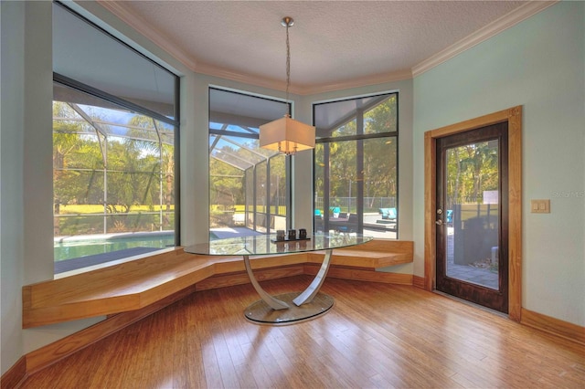 interior space featuring hardwood / wood-style floors, crown molding, a textured ceiling, and a wealth of natural light