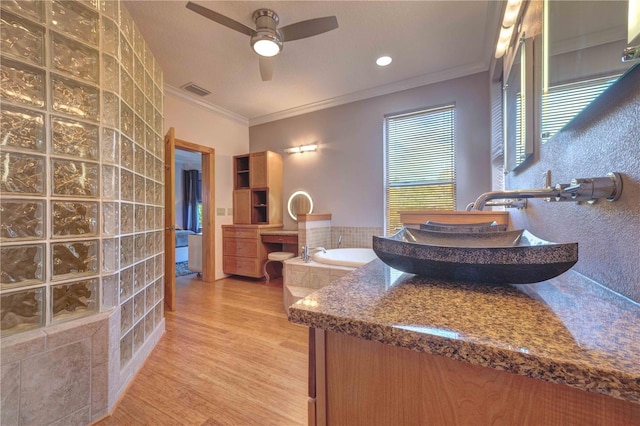 bathroom featuring hardwood / wood-style flooring, ceiling fan, ornamental molding, and sink