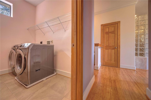 laundry room with independent washer and dryer, light hardwood / wood-style flooring, and ornamental molding