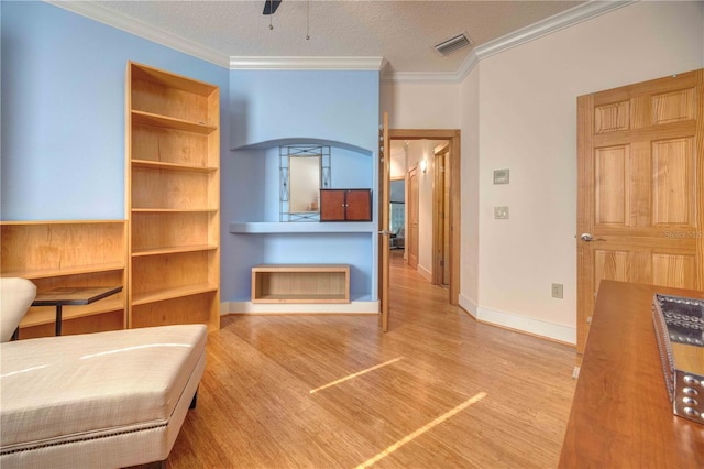 interior space with a textured ceiling, light hardwood / wood-style floors, ceiling fan, and crown molding