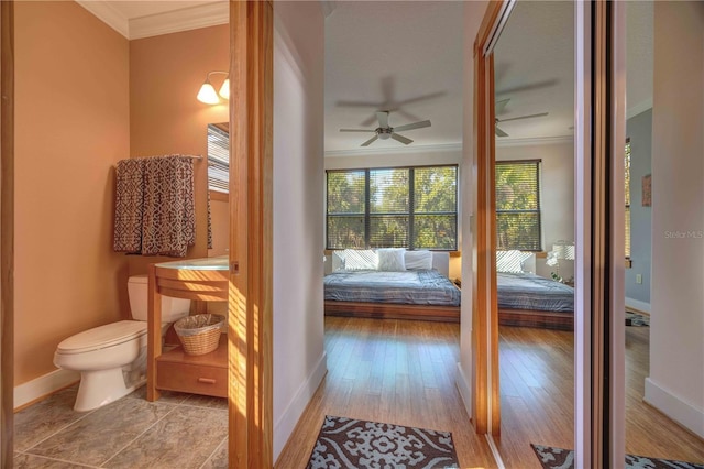 bathroom featuring hardwood / wood-style floors, toilet, ceiling fan, and crown molding