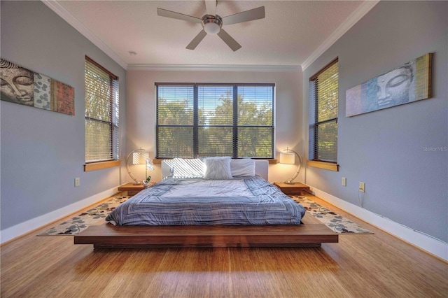 bedroom with multiple windows, ceiling fan, wood-type flooring, and ornamental molding