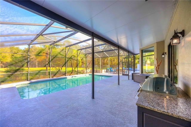 view of pool with glass enclosure, area for grilling, grilling area, and a patio area