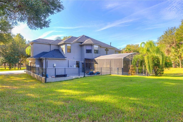 back of property with a lawn and glass enclosure