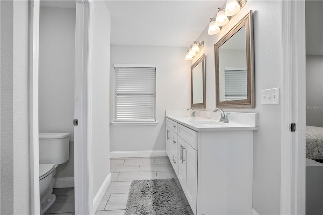 bathroom with tile patterned floors, vanity, a textured ceiling, and toilet