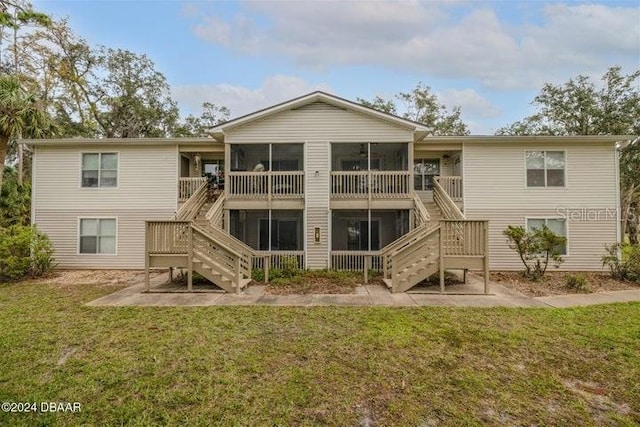 back of property featuring a sunroom and a yard