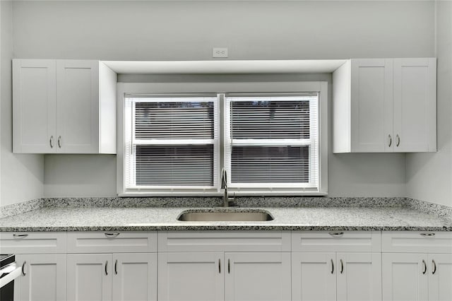907 E N Bay St, Tampa, FL 33603 - kitchen with a sink, white cabinetry, and light stone countertops