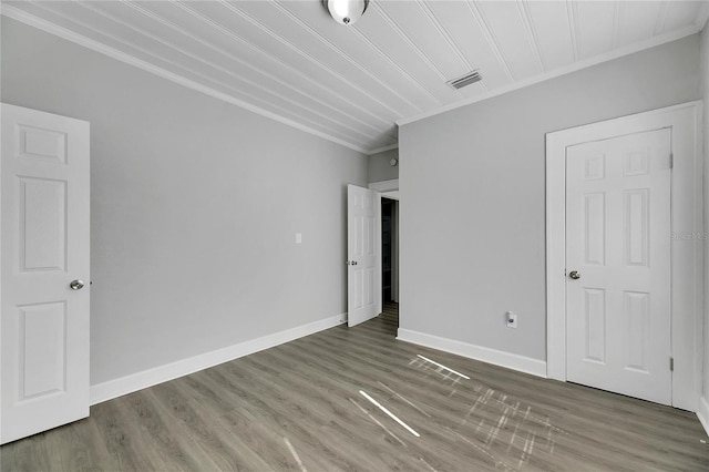 unfurnished bedroom featuring dark hardwood / wood-style flooring and crown molding