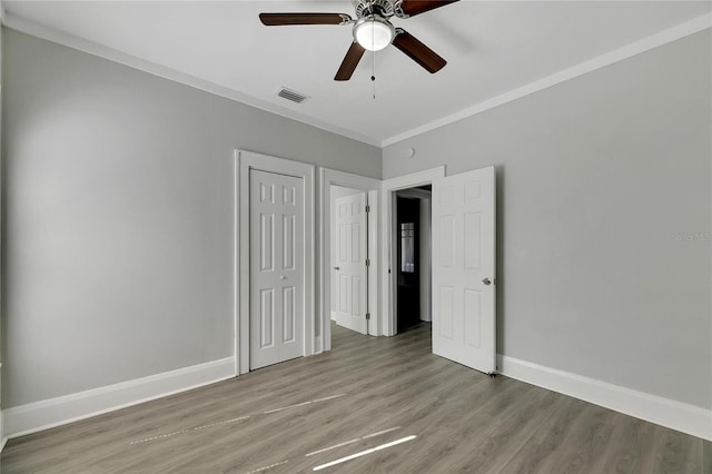 unfurnished bedroom featuring light hardwood / wood-style floors, ceiling fan, and crown molding