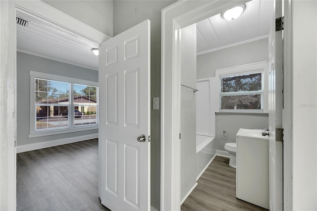 bathroom with toilet, vanity, wood-type flooring, and ornamental molding