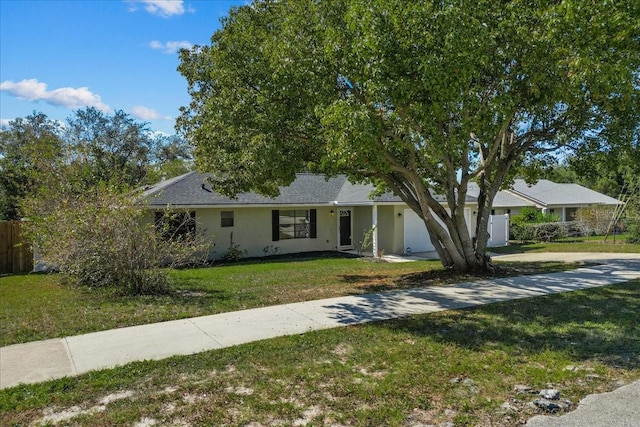 single story home with a garage and a front lawn