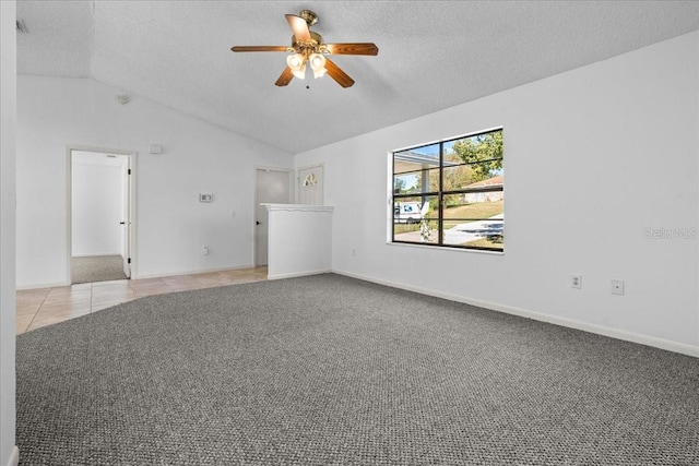 tiled empty room featuring ceiling fan, a textured ceiling, and vaulted ceiling