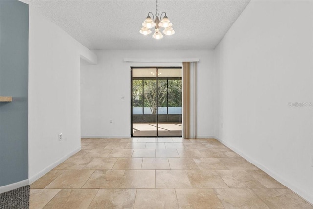 empty room featuring a chandelier, light tile patterned floors, and a textured ceiling