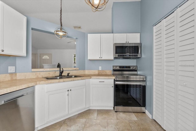 kitchen featuring white cabinets, hanging light fixtures, sink, and appliances with stainless steel finishes