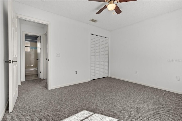 unfurnished bedroom featuring ceiling fan, a closet, a textured ceiling, and dark colored carpet