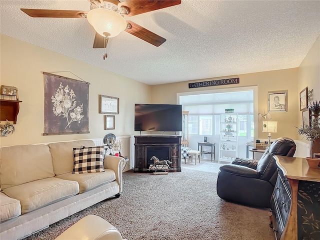 carpeted living room with ceiling fan, a fireplace, and a textured ceiling