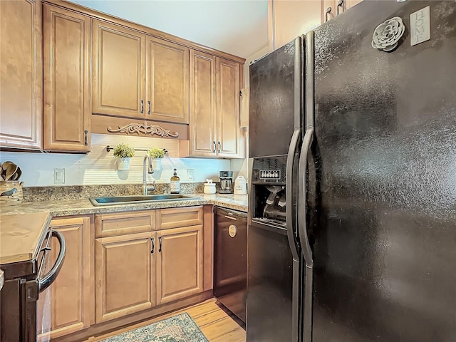 kitchen with black fridge with ice dispenser, light wood-type flooring, electric range oven, and sink