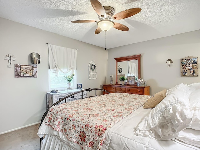 carpeted bedroom featuring ceiling fan and a textured ceiling