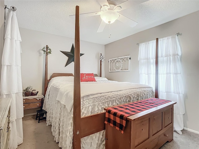 bedroom featuring a textured ceiling, ceiling fan, and light carpet