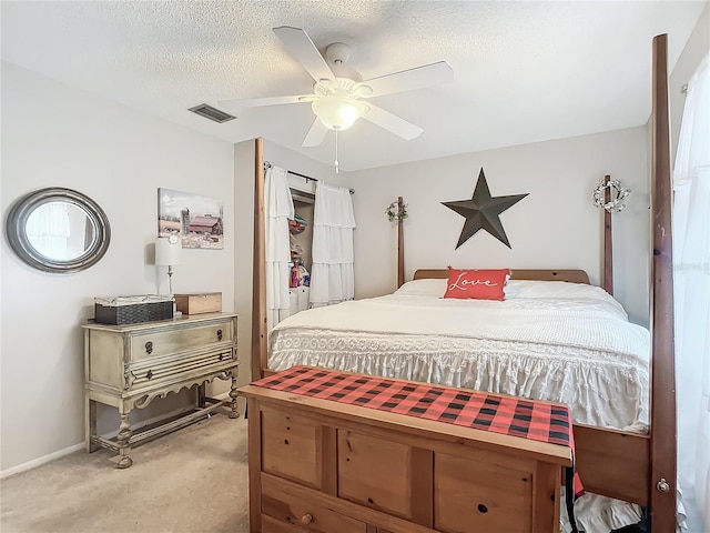 bedroom featuring ceiling fan, light colored carpet, and a textured ceiling