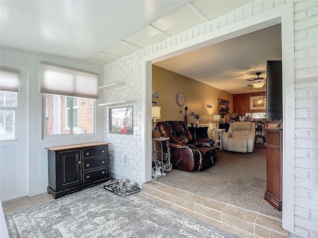 carpeted living room featuring ceiling fan and a textured ceiling