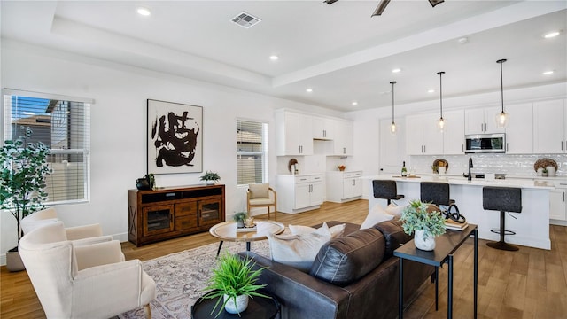 living room featuring sink and light wood-type flooring