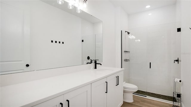 bathroom featuring hardwood / wood-style flooring, vanity, toilet, and an enclosed shower