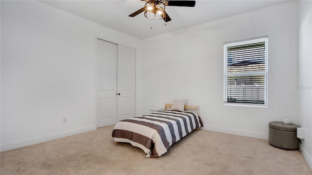 bedroom featuring ceiling fan, a closet, and light carpet