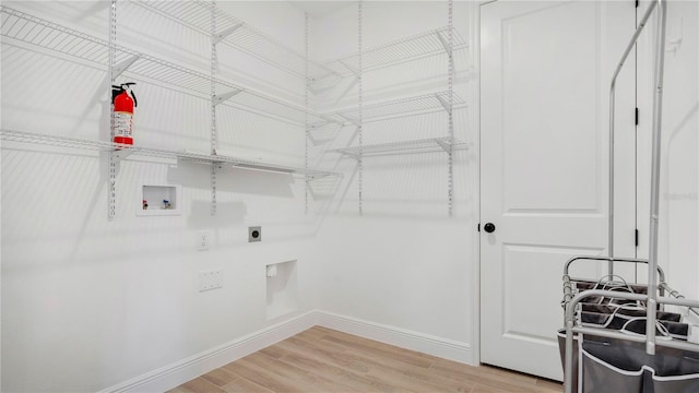 washroom featuring washer hookup, light hardwood / wood-style floors, and electric dryer hookup