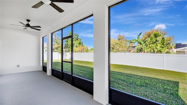 unfurnished sunroom featuring ceiling fan