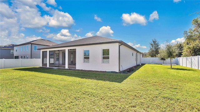 rear view of house featuring a sunroom and a yard