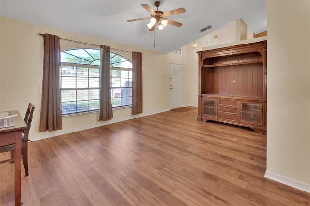 unfurnished living room with hardwood / wood-style flooring, vaulted ceiling, and ceiling fan