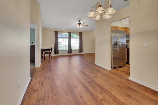 interior space with ceiling fan with notable chandelier and light wood-type flooring