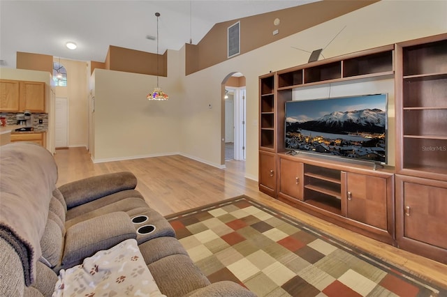 unfurnished living room with high vaulted ceiling and light hardwood / wood-style flooring