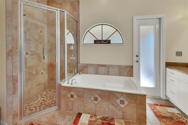 bathroom featuring tile patterned floors, vanity, and shower with separate bathtub