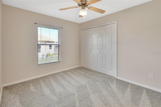 unfurnished bedroom featuring light carpet, a closet, and ceiling fan