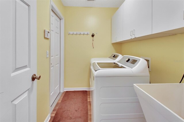 washroom with cabinets, hardwood / wood-style flooring, separate washer and dryer, and sink