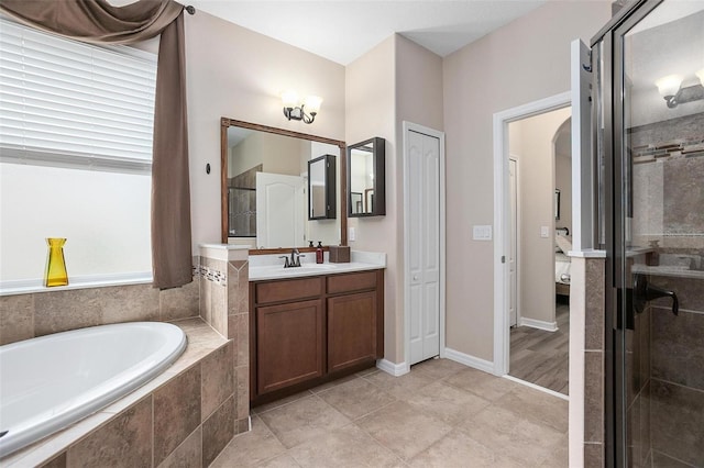 bathroom with tile patterned flooring, shower with separate bathtub, and vanity