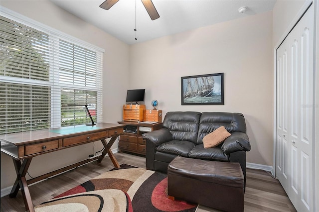 living room with ceiling fan, plenty of natural light, and light wood-type flooring