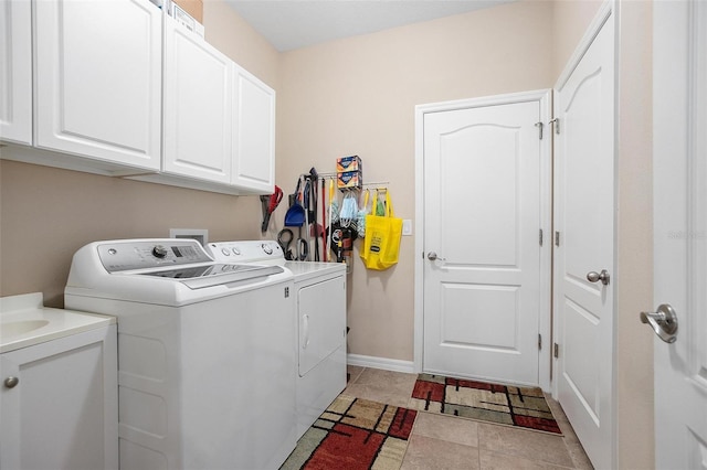 washroom with washer and clothes dryer, cabinets, and light tile patterned floors