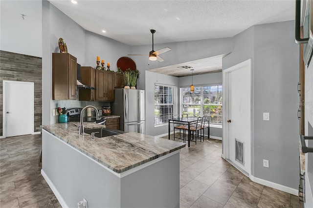 kitchen featuring high vaulted ceiling, ceiling fan, kitchen peninsula, and stainless steel refrigerator