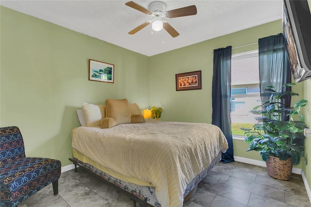 tiled bedroom featuring ceiling fan and a textured ceiling