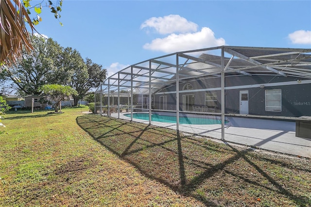 view of pool with a lanai and a lawn