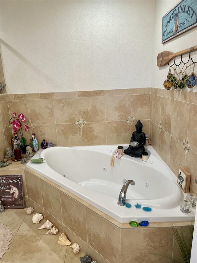 bathroom with tile patterned flooring and tiled bath