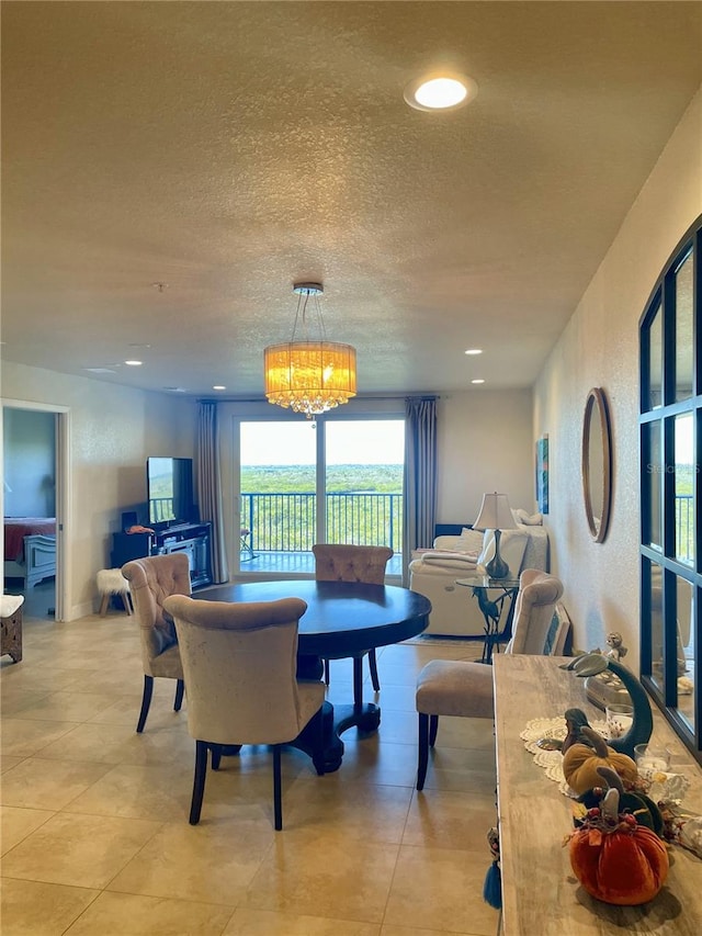 tiled dining room featuring a notable chandelier and a textured ceiling